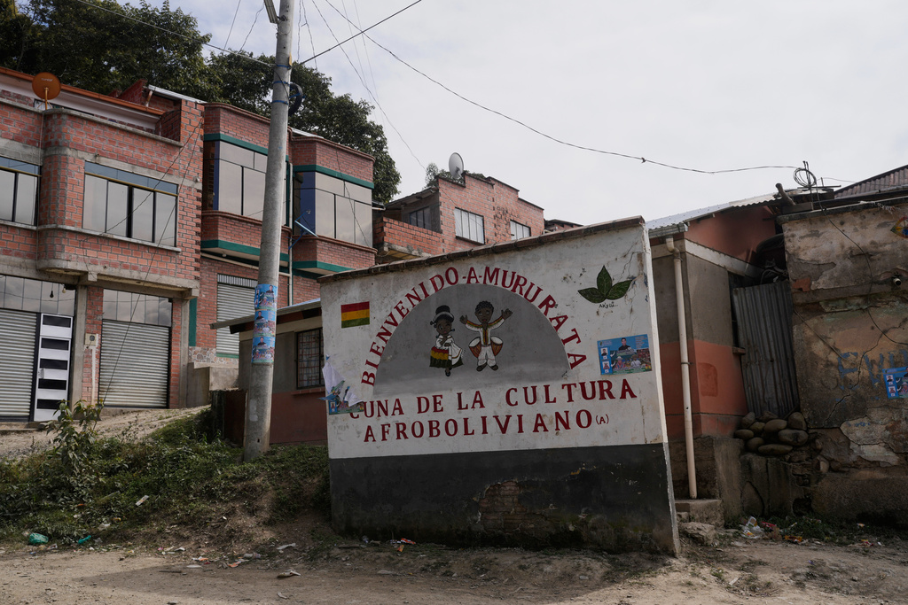 A sign with a message that reads in Spanish: “Welcome to Mururata, cradle of Afro-Bolivian culture” stands at the entrance of Mururata, Bolivia, Sunday, Aug. 3, 2025. (AP Photo/Juan Karita)