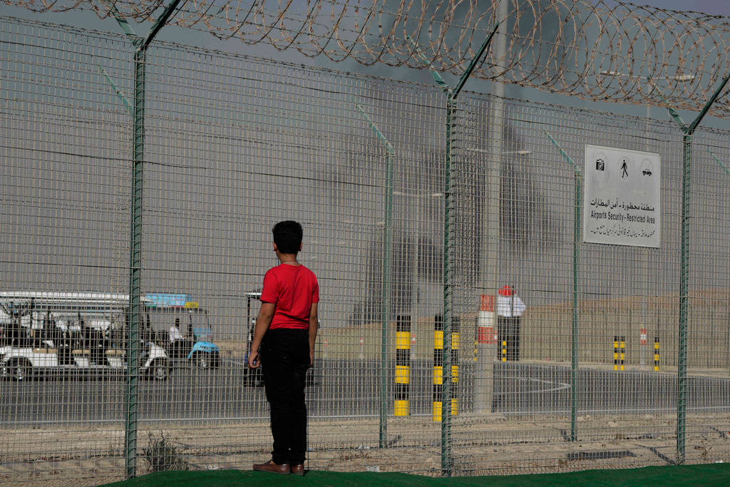 A bystander watches as an Indian HAL Tejas crashes during a demonstration at the Dubai Air Show, at Al Maktoum International Airport at Dubai World Central, Dubai, United Arab Emirates, Friday Nov. 21, 2025. (AP Photo/Jon Gambrell)