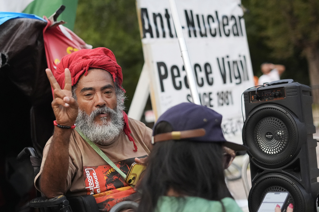 Philipos Melaku-Bello gestures the peace sign at the White House Peace Vigil in Lafayatte Park across the street from the White House in Washington, Friday, Sept. 5, 2025. (AP Photo/Pablo Martinez Monsivais)