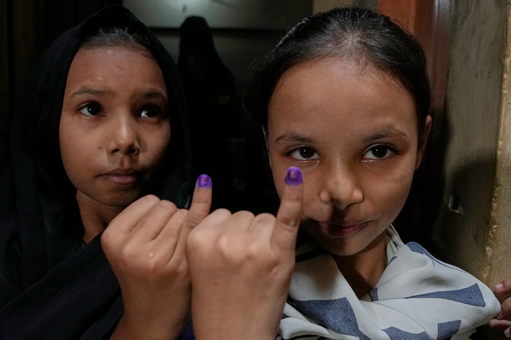 Girls display fingers marked by a health worker after administrating an injection of human papillomavirus (HPV) vaccine during a nationwide campaign aiming to protect girls from cervical cancer, at a neighbourhood of Karachi, Pakistan, Wednesday, Sept. 24, 2025. (AP Photo/Fareed Khan)