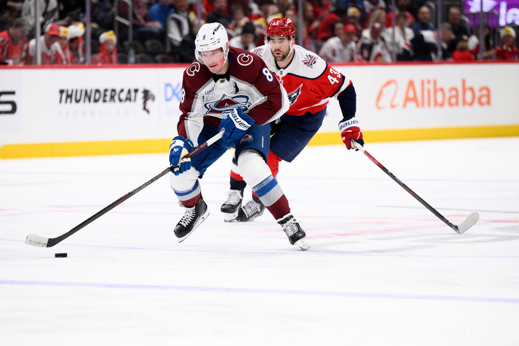 Colorado Avalanche defenseman Cale Makar (8) skates with the puck past Washington Capitals right wing Tom Wilson (43) during the second period of an NHL hockey game, Sunday, March 22, 2026, in Washington. (AP Photo/Nick Wass)