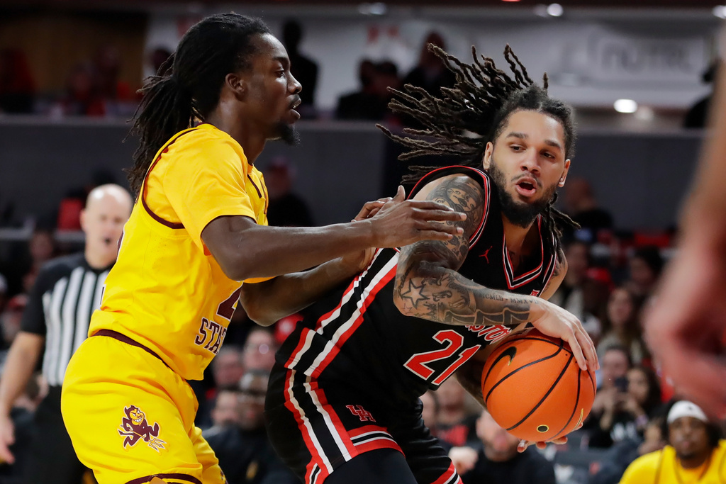 Houston guard Emanuel Sharp (21) attempts to drive around Arizona State guard Anthony Johnson, left, during the first half of an NCAA college basketball game Sunday, Jan. 18, 2026, in Houston. (AP Photo/Michael Wyke)