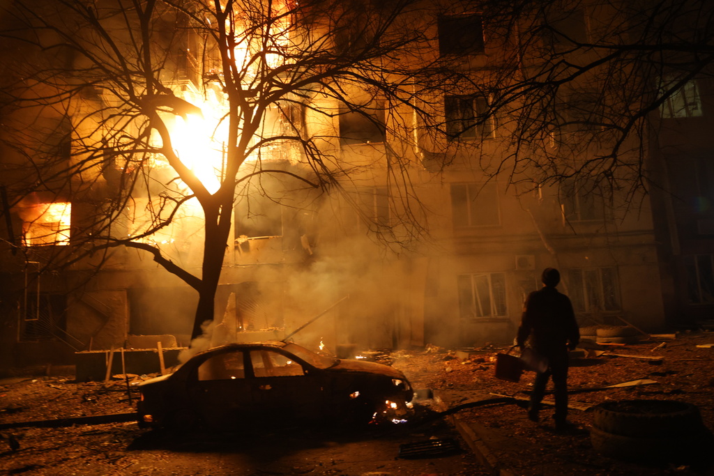 A man walks in front of burning residential building after a Russian attack on Zaporizhzhia, Ukraine, Wednesday, Nov. 26, 2025. (AP Photo/Kateryna Klochko)