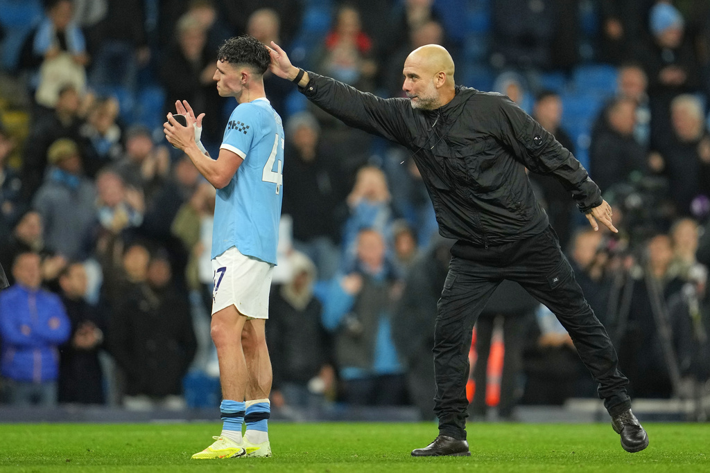 Manchester City's head coach Pep Guardiola celebrates with Manchester City's Phil Foden at the end of the English Premier League soccer match between Manchester City and Liverpool in Manchester, England, Sunday, Nov. 9, 2025. (AP Photo/Jon Super)