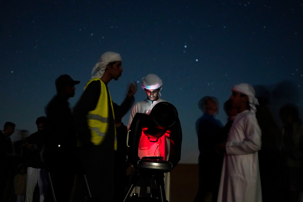 This long-exposure photograph shows Emiratis gathered around a telescope in the Al Quaa Desert outside of Abu Dhabi, United Arab Emirates, Saturday, May 23, 2026. (AP Photo/Jon Gambrell)