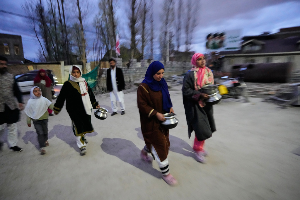 Shiite Muslim women arrive carrying kitchenware to donate at a relief drive for Iran in Budgam, Indian-controlled Kashmir, Monday, March 23, 2026. (AP Photo/Mukhtar Khan)