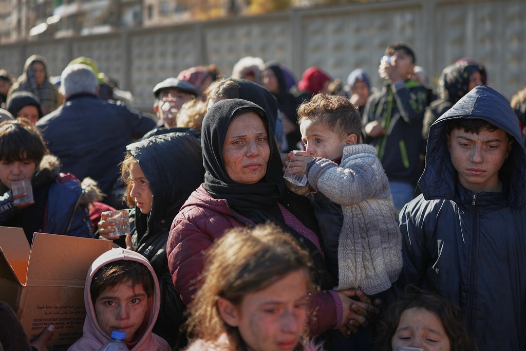 Civilians evacuate an area of the Sheikh Maqsoud neighborhood, where clashes between government forces and Kurdish fighters have been taking place in the northern city of Aleppo, Syria, Saturday, Jan. 10, 2026. (AP Photo/Ghaith Alsayed)