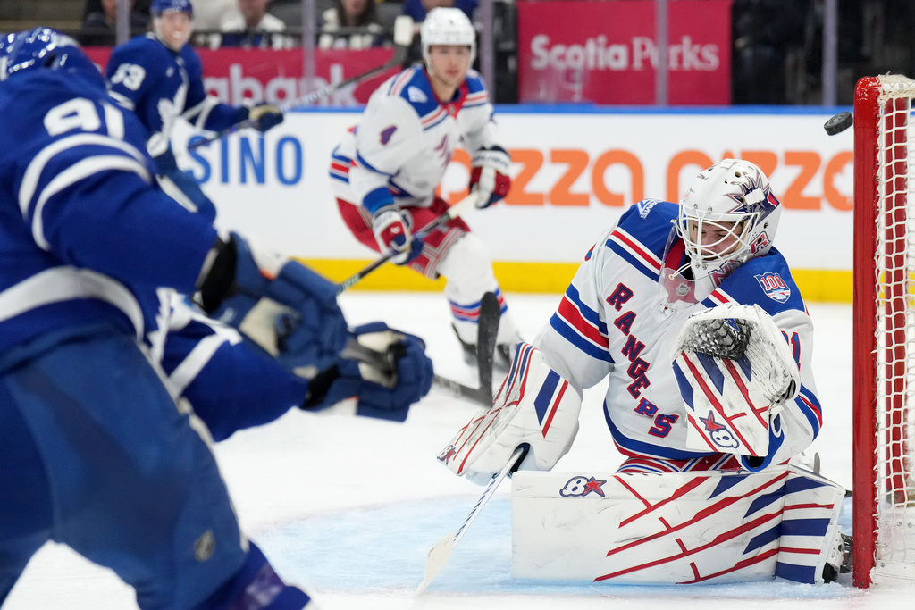 Toronto Maple Leafs forward John Tavares (91) hits the post on a goal attempt as New York Rangers goaltender Igor Shesterkin (31) reacts during the second period of an NHL hockey game in Toronto, Wednesday, March 25, 2026. (Nathan Denette/The Canadian Press via AP)