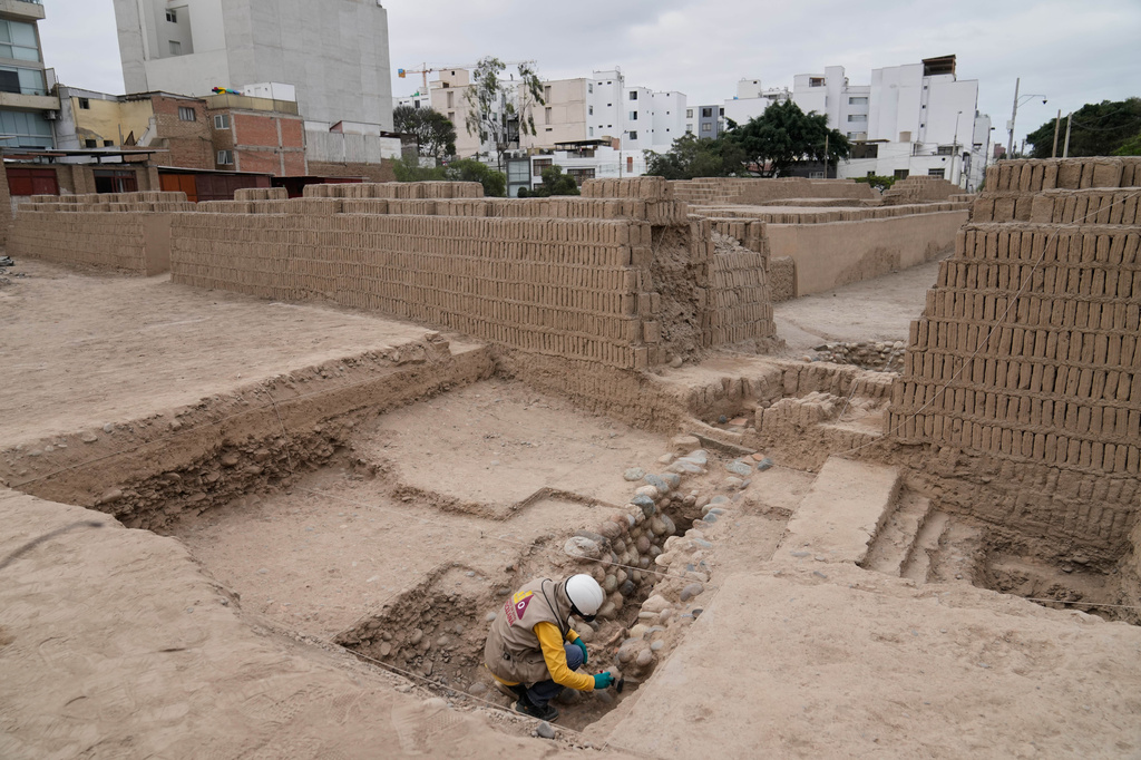 An archaeologist excavates skeletal remains at the Huaca Pucllana archaeological site in Lima, Peru, Tuesday, Aug. 18, 2026. The remains are from the Lima culture, according to the excavation's leader Gladys Paz. (AP Photo/Martin Mejia)