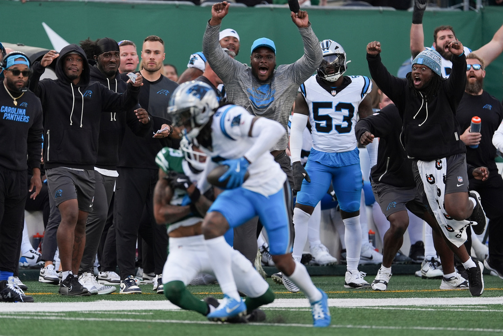 The Carolina Panthers sideline reacts as cornerback Jaycee Horn (8) intercepts a pass against the New York Jets during the fourth quarter of an NFL football game, Sunday, Oct. 19, 2025, in East Rutherford, N.J. (AP Photo/Seth Wenig)