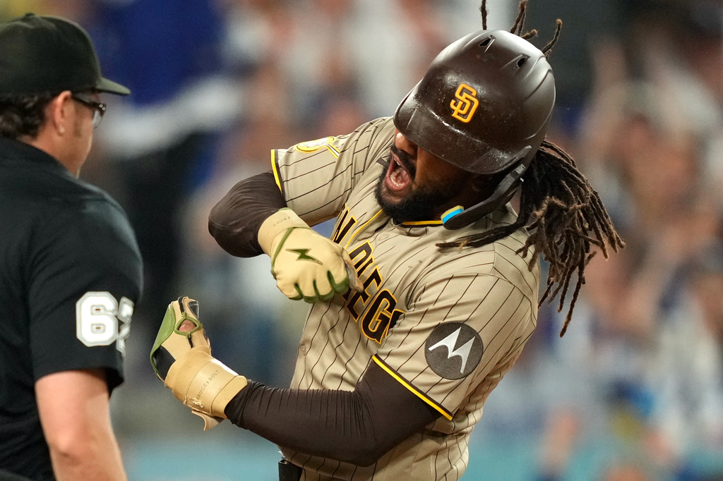 San Diego Padres' Fernando Tatis Jr. celebrates after scoring on a sacrifice fly by Manny Machado after Los Angeles Dodgers catcher Will Smith made a late tag during the fifth inning of a baseball game Wednesday, Sept. 23, 2026, in Los Angeles. (AP Photo/Mark J. Terrill)