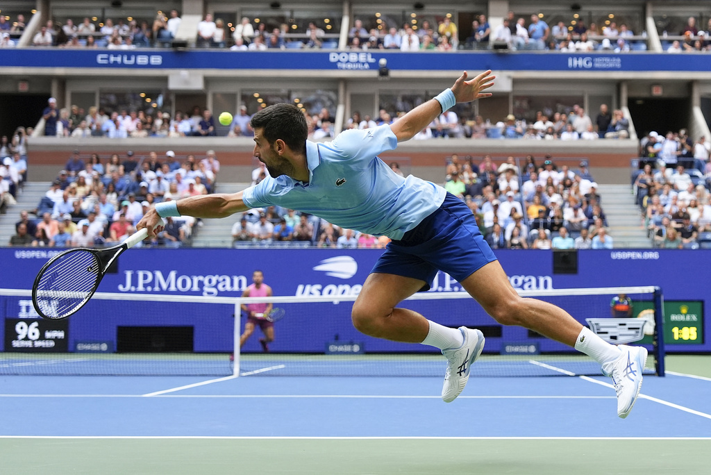Novak Djokovic, of Serbia, returns a shot to Carlos Alcaraz, of Spain, during the men's singles semifinals of the U.S. Open tennis championships, Friday, Sept. 5, 2025, in New York. (AP Photo/Yuki Iwamura)