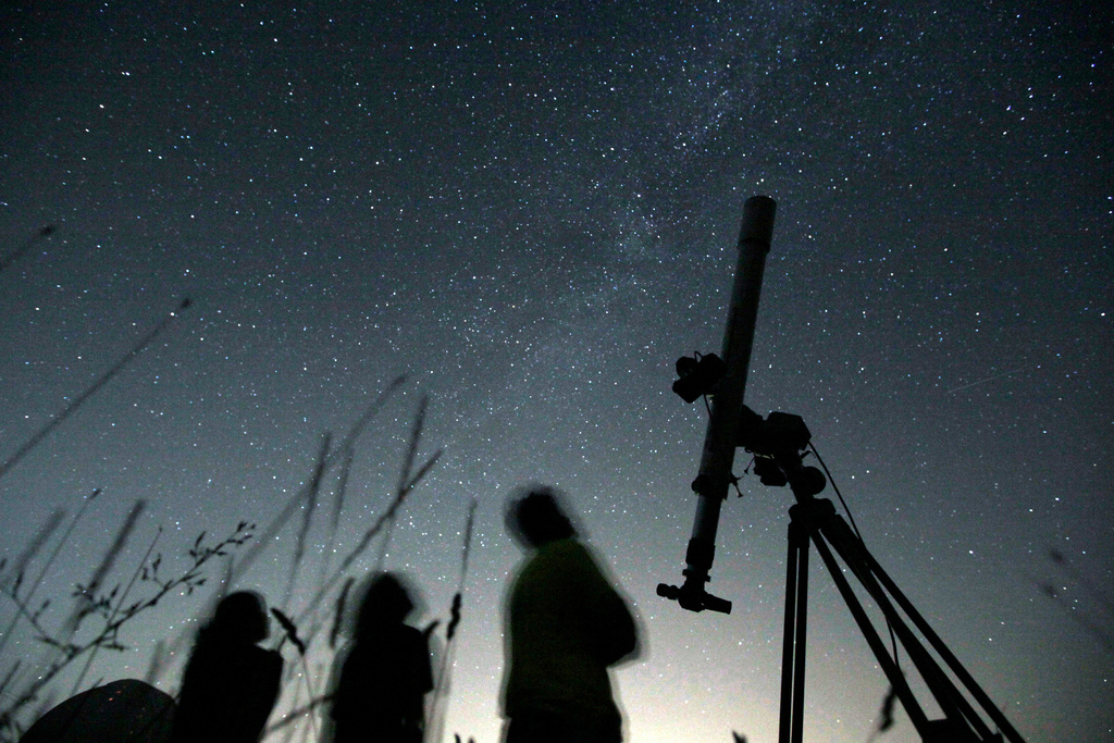 FILE - People look up to the sky from an observatory near the village of Avren, Bulgaria, Aug. 12, 2009. (AP Photo/Petar Petrov, File)