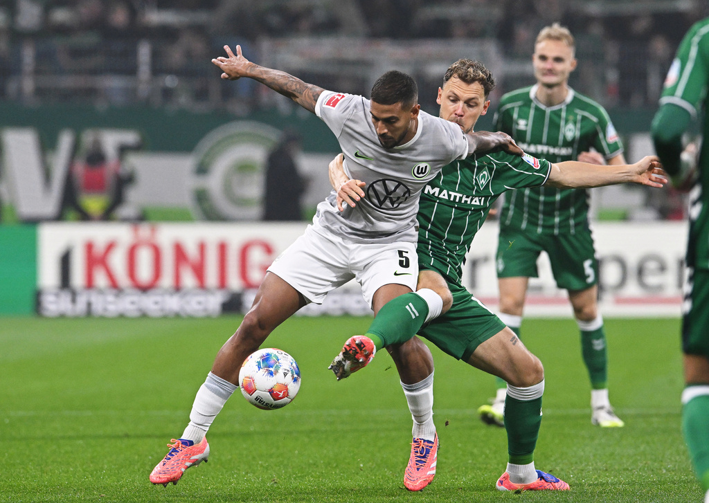 Bremen's Senne Lynen, right, fights for the ball against Wolfsburg's Vinicius Souza during the German Bundesliga soccer match between Werder Bremen and VfL Wolfsburg in Bremen, Germany, Friday, Nov. 7, 2025. (Carmen Jaspersen/dpa via AP)