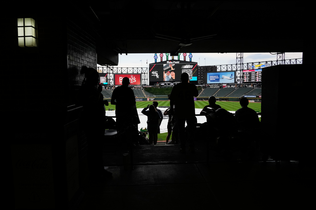 Baseball fans wait during a rain delay before a baseball game between the Atlanta Braves and the Chicago White Sox in Chicago, Thursday, June 11, 2026. (AP Photo/Nam Y. Huh)