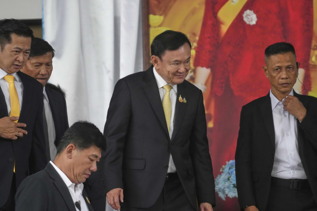 Former Thai Prime Minister Thaksin Shinawatra, center, leaves after a court acquitted Thaksin of royal defamation at Criminal Court in Bangkok, Thailand, Friday, Aug. 22, 2025. (AP Photo/Sakchai Lalit)