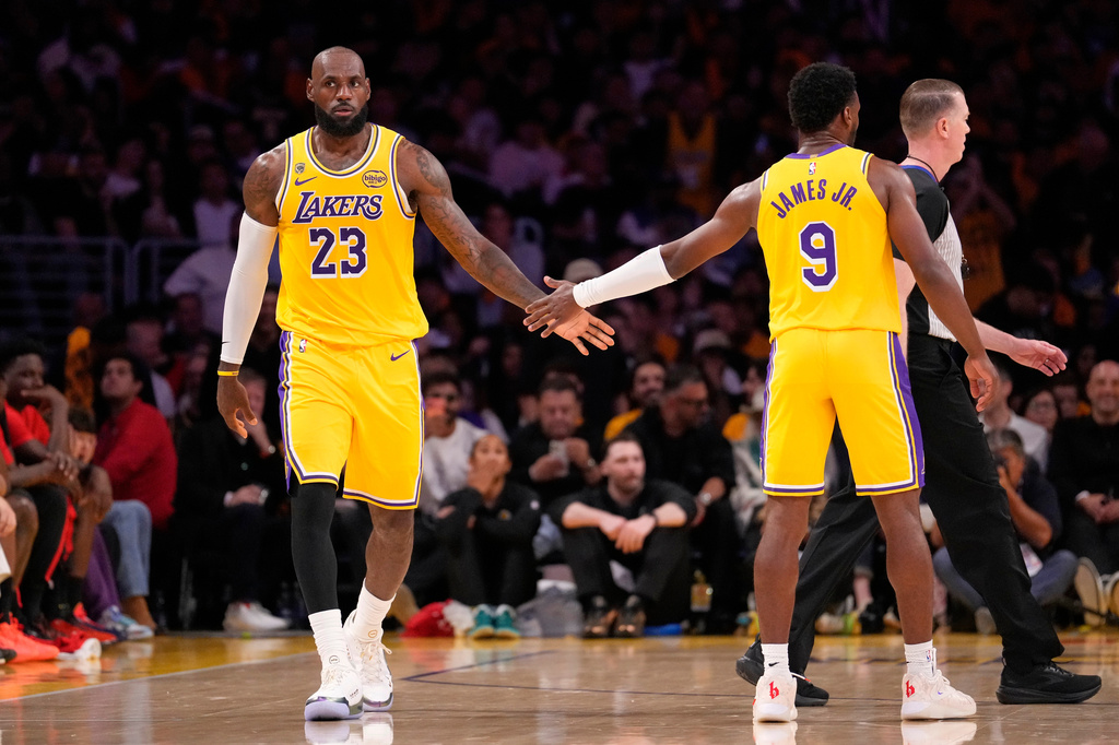Los Angeles Lakers forward LeBron James, left, slaps hands with guard Bronny James during the first half in Game 1 of a first-round NBA playoffs basketball series against the Houston Rockets, Saturday, April 18, 2026, in Los Angeles. (AP Photo/Mark J. Terrill)