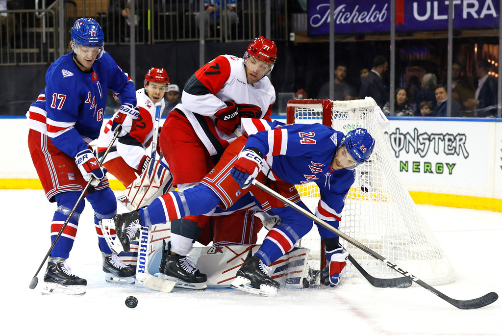 Carolina Hurricanes left wing Taylor Hall (71) battles New York Rangers Will Borgen (17) and Carson Soucy (24) during the first period of an NHL hockey game, Tuesday Nov. 4, 2025, in New York. (AP Photo/Noah K. Murray)