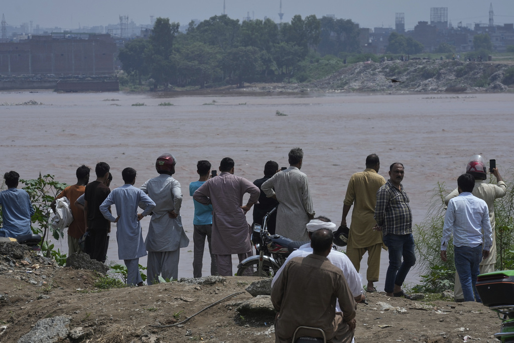 People look overflowing Ravi River after torrential rains on the outskirts of Lahore, Pakistan, Aug. 28, 2025. (AP Photo/K.M. Chaudary)