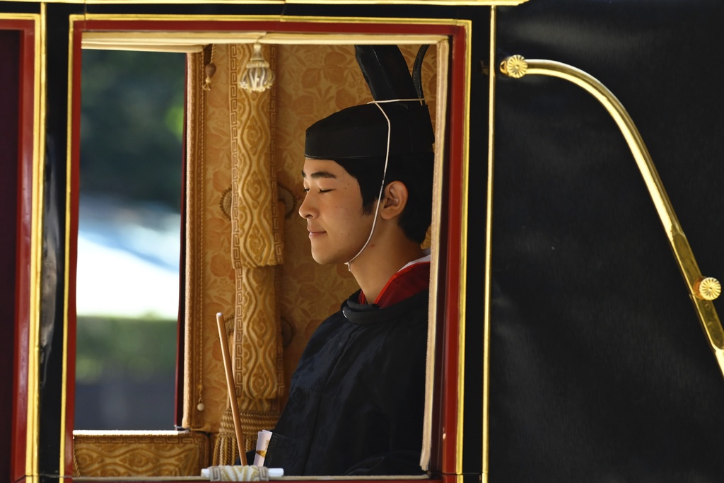 Japan's Prince Hisahito is seen in traditional attire inside a horse-drawn carriage as he leaves the Imperial Palace after attending his coming-of-age ceremony to be recognized as an adult, on his 19th birthday in Tokyo, Saturday, Sept. 6, 2025. (David Mareuil/Pool Photo via AP)