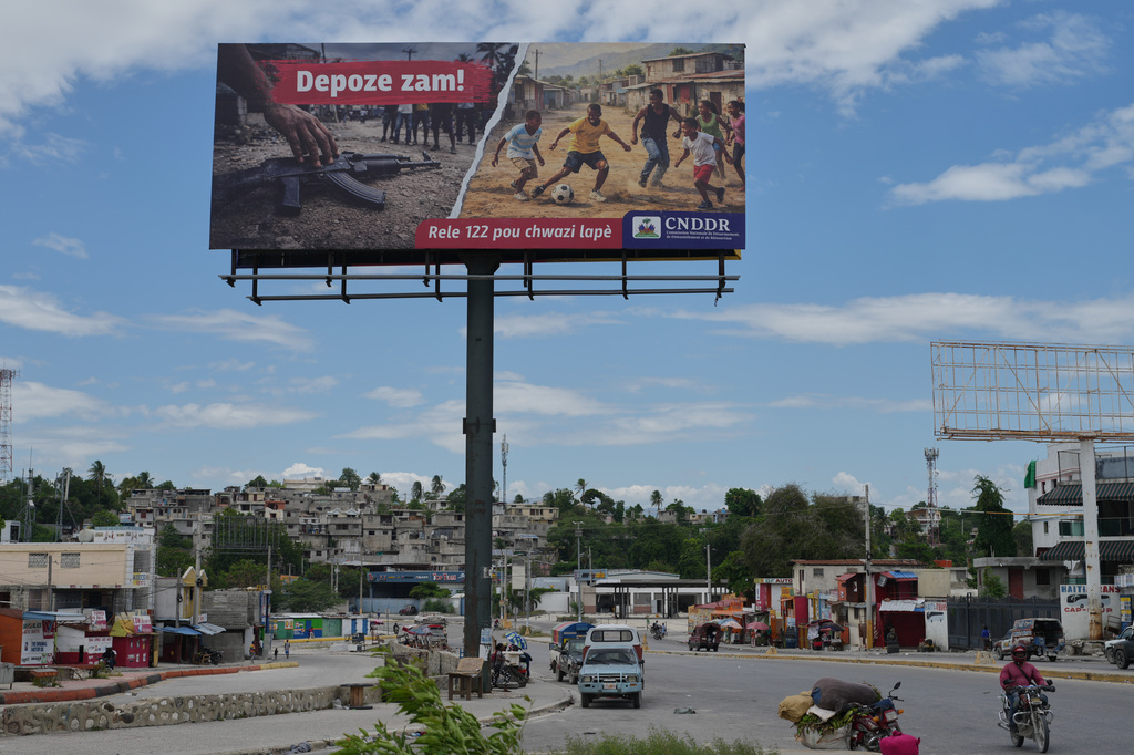 A billboard installed as part of a government disarmament campaign stands in Port-au-Prince, Haiti, Monday, May 11, 2026. (AP Photo/Odelyn Joseph)