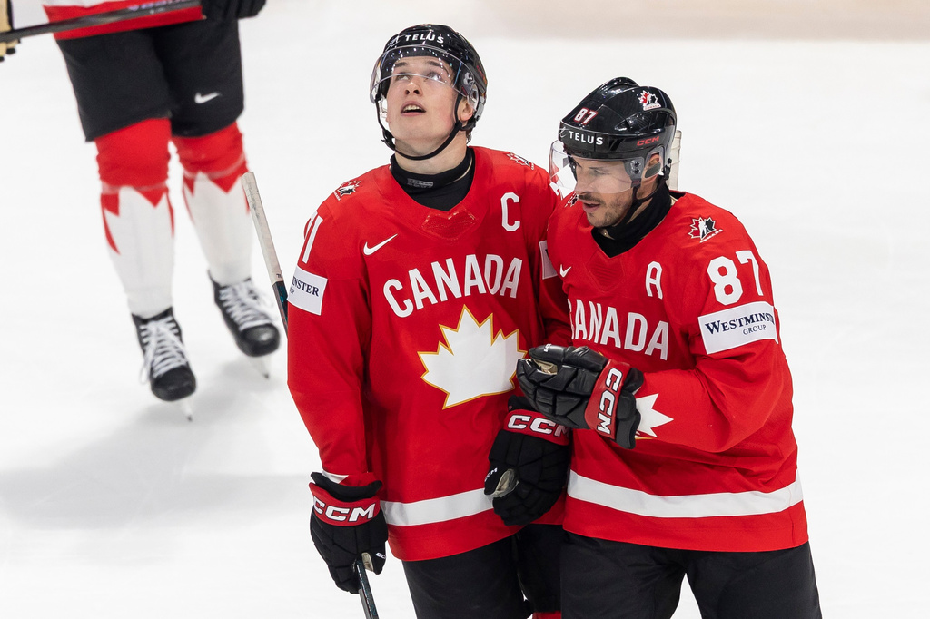 Canada's Macklin Celebrini, left, and Canada's Sidney Crosby, right, react during the 2026 IIHF Men's Ice Hockey World Championship preliminary round group B game between Canada and Denmark, in Fribourg, Switzerland, Monday, May 18, 2026. (Cyril Zingaro/Keystone via AP)