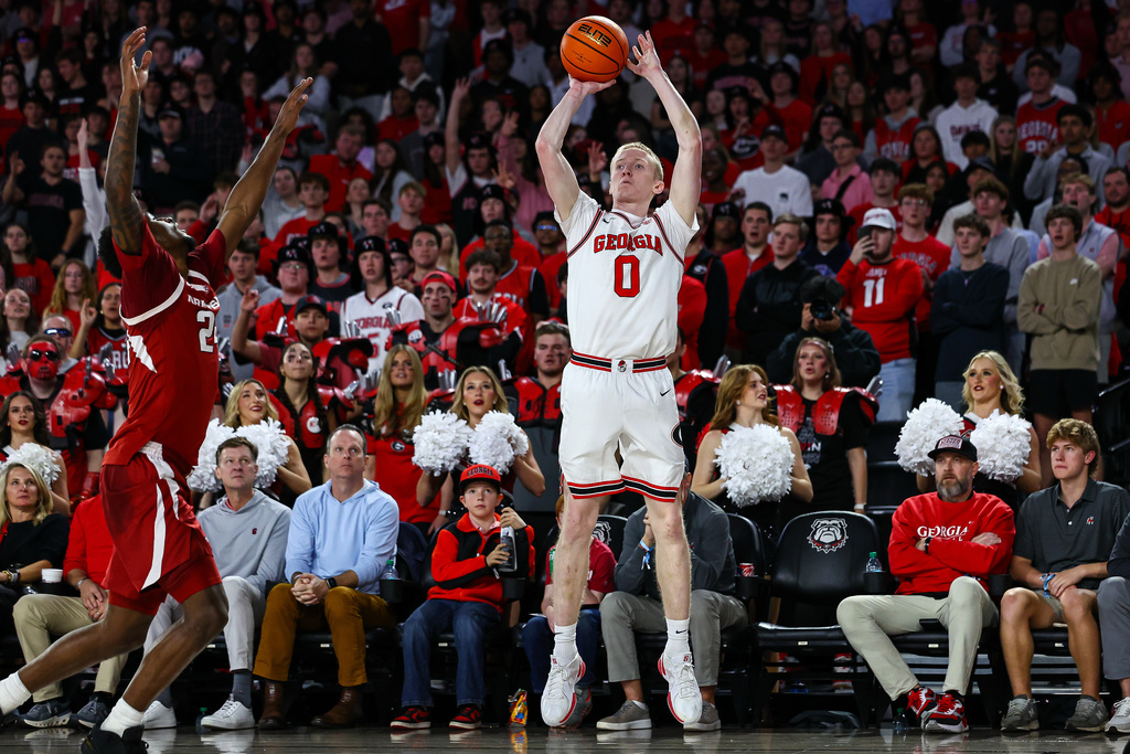 Georgia guard Blue Cain (0) shoots against Arkansas forward Billy Richmond III, left, during the first half of an NCAA college basketball game, Saturday, Jan. 17, 2026, in Athens, Ga. (AP Photo/Colin Hubbard)