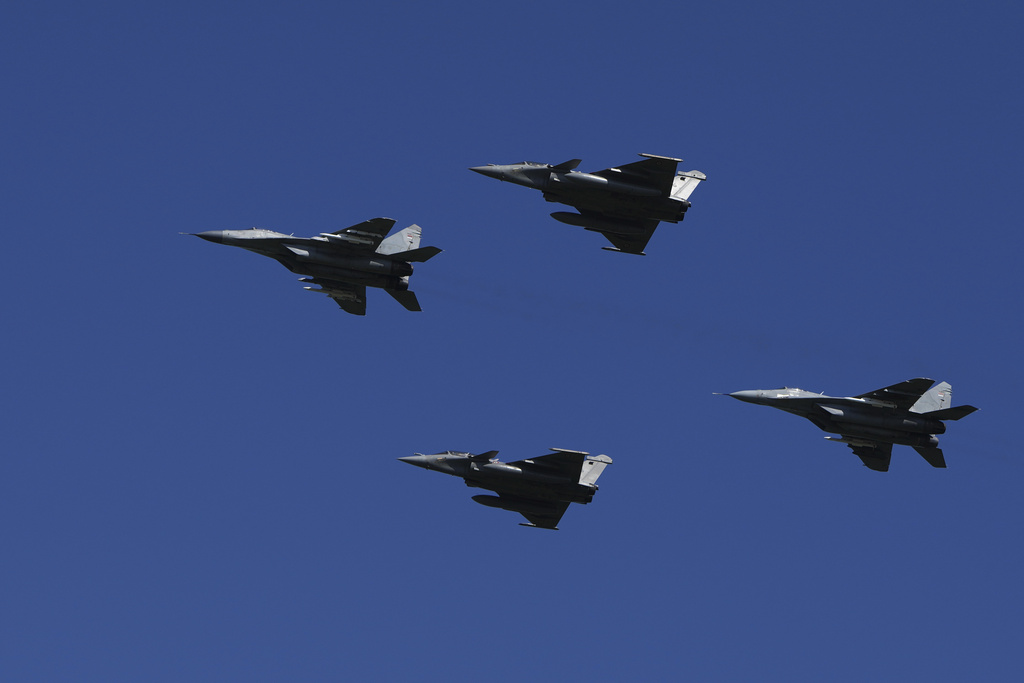 Serbian army MiG-29 jets, left and right, and French Air Force Rafale fighter jets fly in the sky during a military parade in Belgrade, Serbia, Saturday, Sept. 20, 2025. (AP Photo/Darko Vojinovic)
