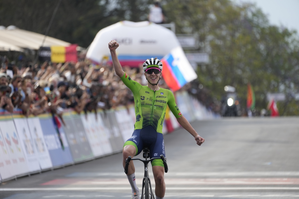 Slovenia's Tadej Pogacar celebrates winning the men's Elite road race, at the road cycling World Championships in Kigali, Rwanda, Sunday, Sept. 28, 2025. (AP Photo/Jerome Delay)
