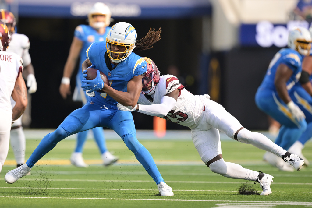 Los Angeles Chargers wide receiver Quentin Johnston (1) is tackled by Washington Commanders safety Darnell Savage after a catch during the second half of an NFL football game Sunday, Oct. 5, 2025, in Inglewood, Calif. (AP Photo/Carrie Giordano )