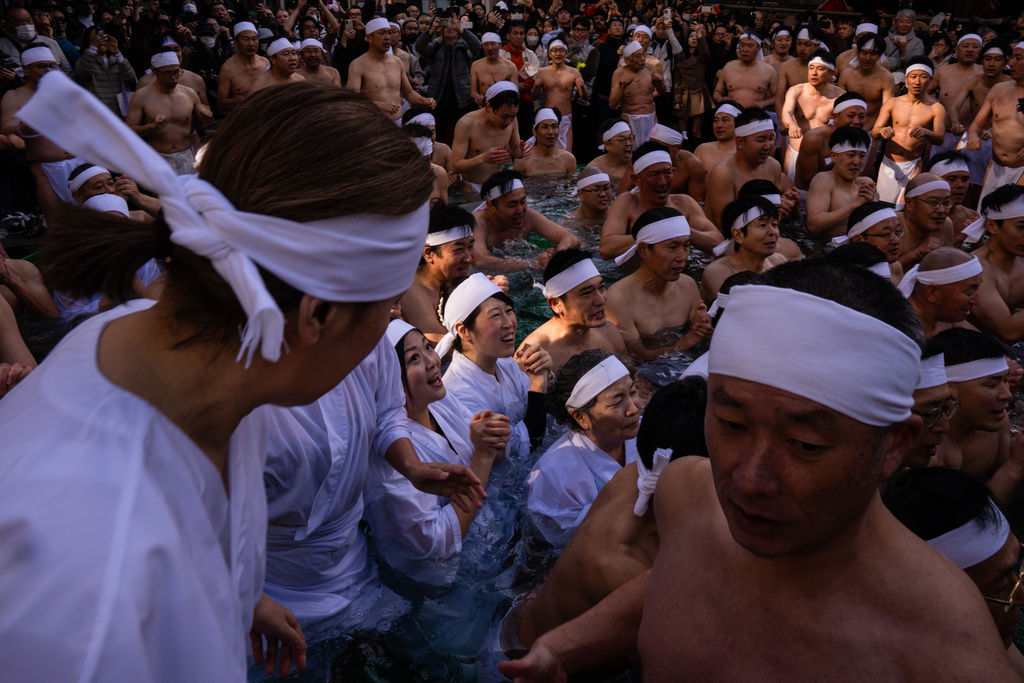 Participants bathe in ice-cold water to purify their souls and pray for good health during a New Year's ritual at Teppozu Inari Shrine in Tokyo, Sunday, Jan. 11, 2026. (AP Photo/Louise Delmotte)