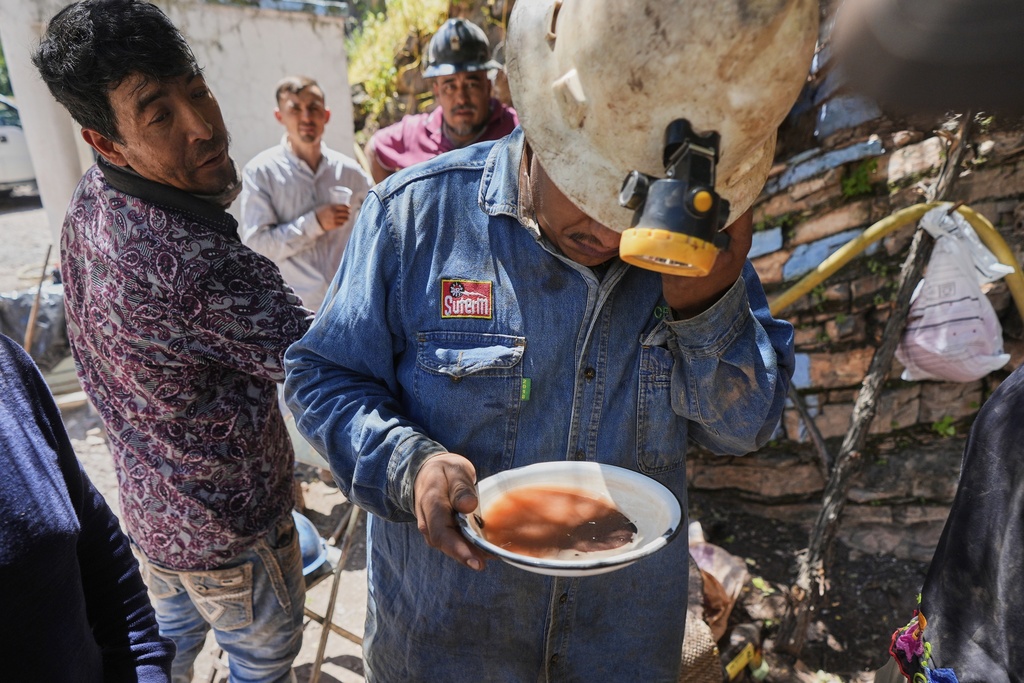 A miner analyzes a sample of sand and rocks to determine the amount of mercury ore before cooking it in San Joaquin, Mexico, Tuesday, Aug. 19, 2025. (AP Photo/Fernando Llano)