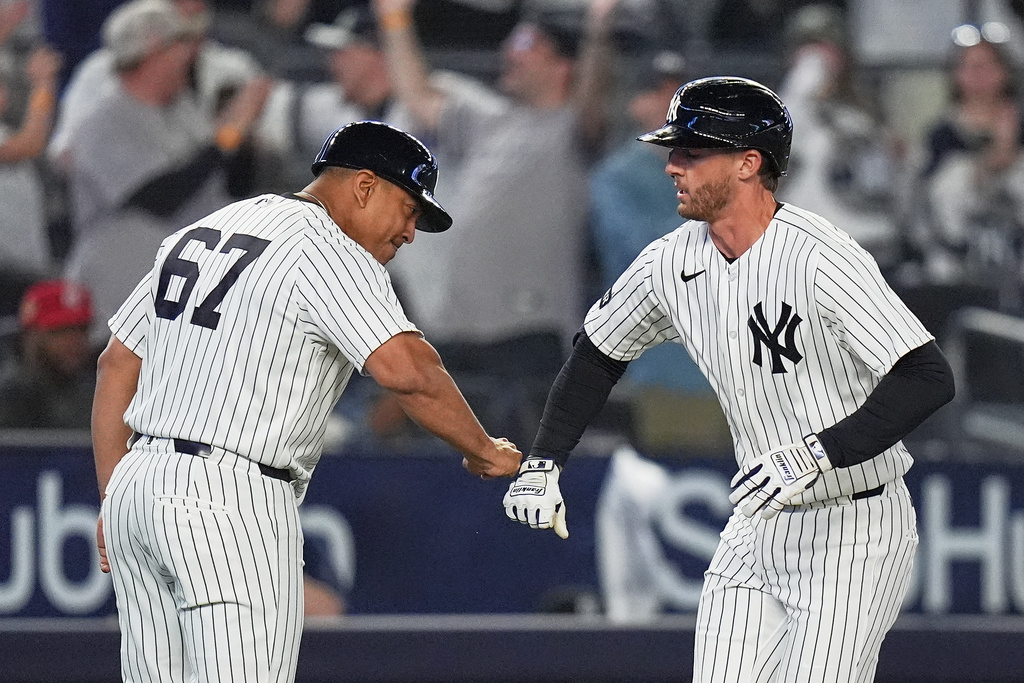 New York Yankees' Ryan McMahon, right, celebrates with third base coach Luis Rojas as he runs the bases after hitting a two-run home run during the eighth inning of a baseball game against the Kansas City Royals Friday, April 17, 2026, in New York. (AP Photo/Frank Franklin II)