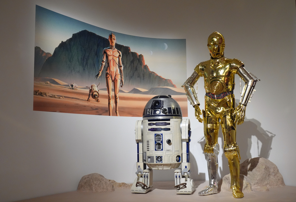 Production designer Norman Reynolds' robot R2-D2, left, and John Mollo's costume for the C-3PO character from the "Star Wars" franchise are displayed in the Cinema Gallery during a preview of the Lucas Museum of Narrative Art on Monday, Aug. 31, 2026, in Los Angeles. (AP Photo/Chris Pizzello)