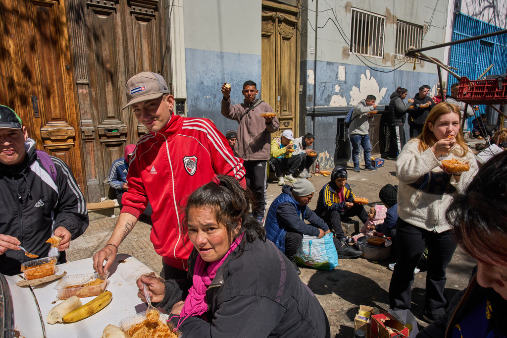 People eat food distributed for free by the Union of Workers of the Popular Economy in Buenos Aires, Argentina, Wednesday, Sept. 23, 2026. (AP Photo/Rodrigo Abd)