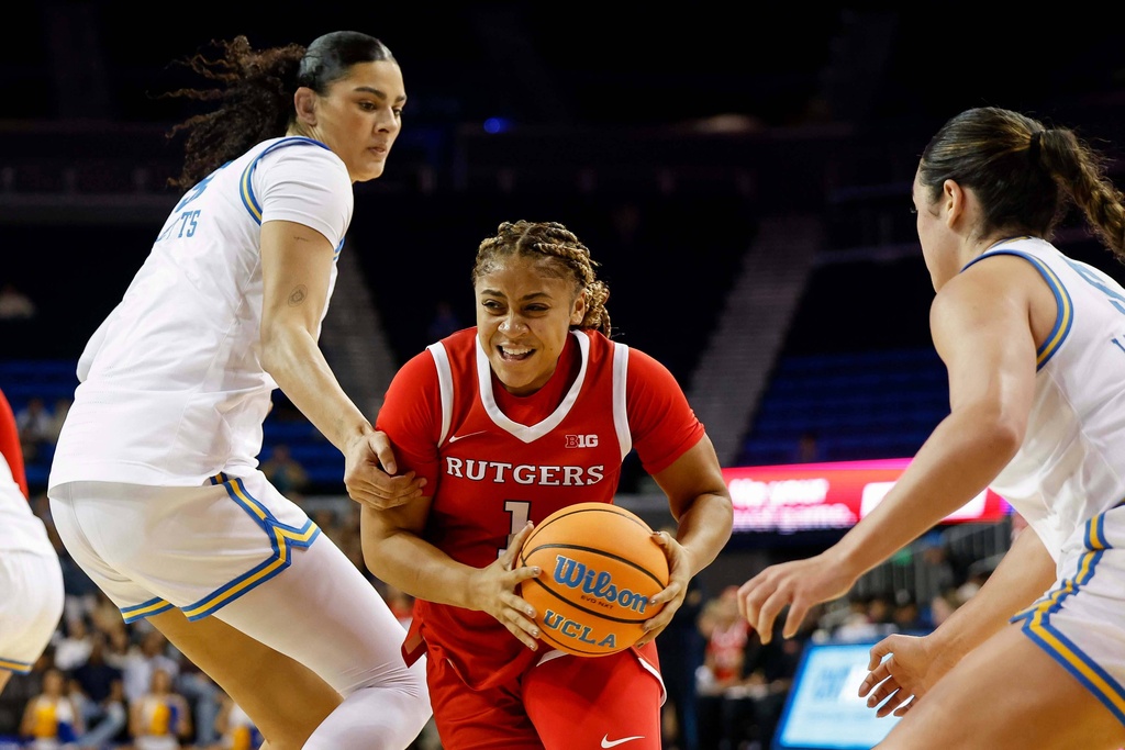 Rutgers guard Lauryn Swann (1) dribbles past UCLA center Lauren Betts (51) and UCLA guard Charlisse Leger-Walker (5) during the first half of an NCAA college basketball game Wednesday, Feb. 4, 2026, in Los Angeles. (AP Photo/Caroline Brehman)