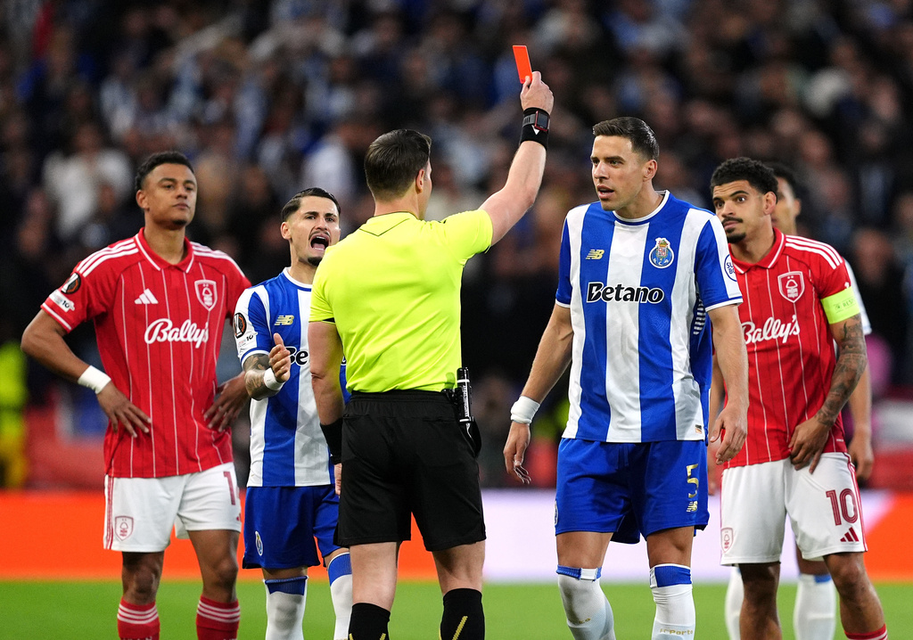 Porto's Jan Bednarek, center, is shown a red card and sent off by referee Danny Makkelie during the Europa League quarterfinal second leg soccer match between Nottingham Forest and Porto in Nottingham, England, Thursday April 16, 2026. (Martin Rickett/PA via AP)