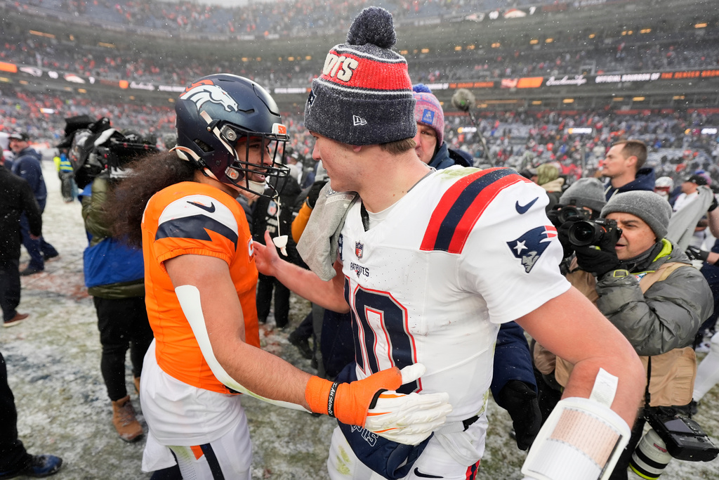 Denver Broncos safety Talanoa Hufanga, left, greets New England Patriots quarterback Drake Maye after the AFC Championship NFL football game, Sunday, Jan. 25, 2026, in Denver. (AP Photo/Ashley Landis)
