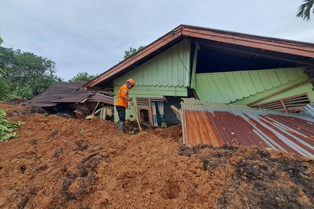 In this photo released on Saturday, Nov. 29, 2025 by the Indonesian National Search and Rescue Agency (BASARNAS), rescuers search for victims at a village hit by a landslide in Batu Goading, North Sumatra, Indonesia. (BASARNAS via AP)