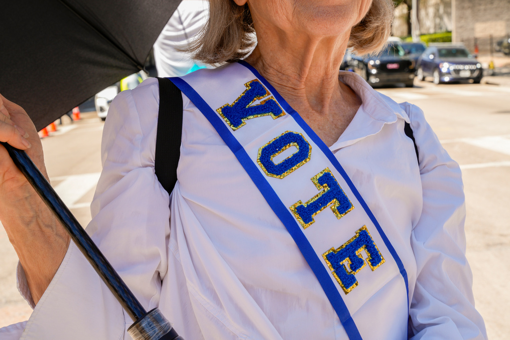 Protestor, Linda James, poses for photo with her "VOTE" sash at the Dallas March on the RNC Midterm Convention in Dallas, Thursday, Sept. 10, 2026. (AP Photo/Gabriela Passos)