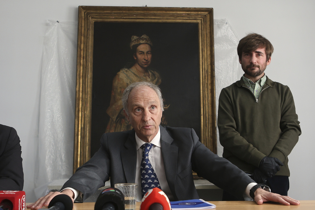 Prosecutor Daniel Adlers gives a press conference in front of Giuseppe Ghislandi's 18th-century painting "Portrait of a Lady," reportedly stolen by a Nazi officer during World War II and discovered in the home of his daughter after appearing in a real estate listing, in Mar del Plata, Argentina, Wednesday, Sept. 3, 2025. (AP Photo/Christian Heit)
