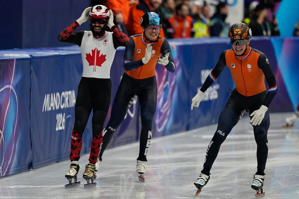 Steven Dubois of Canada wins gold as Melle van 't Wout of the Netherlands wins silver, left, and Jens van 't Wout of the Netherlands wins bronze during the short track speed skating men's 500m at the 2026 Winter Olympics, in Milan, Italy, Wednesday, Feb. 18, 2026. (AP Photo/Ashley Landis)