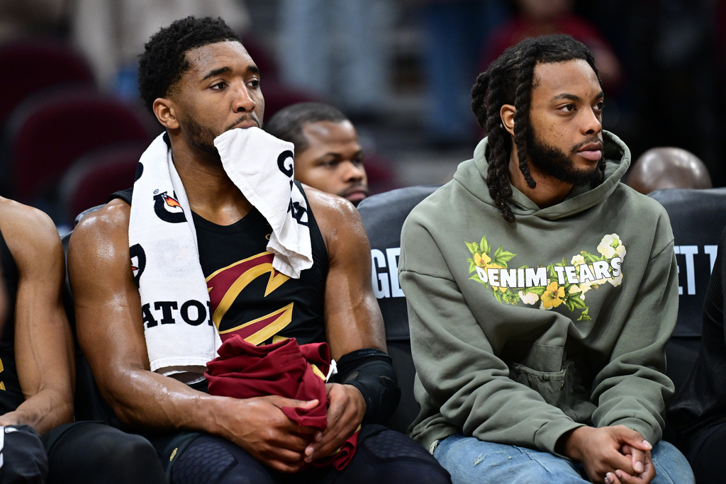 Cleveland Cavaliers guard Donovan Mitchell, left, bites his towel while sitting next to guard Darius Garland, right, in the second half of an NBA basketball game against the Oklahoma City Thunder, Monday, Jan. 19, 2026, in Cleveland. (AP Photo/David Dermer)