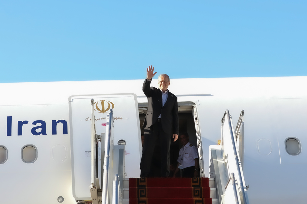 In this photo released by the Iranian Presidency Office, President Masoud Pezeshkian waves to media and officials as he boards his plane while leaving Mehrabad airport for New York to attend the UN General Assembly, in Tehran, Iran, Tuesday, Sept. 22, 2026. (Iranian Presidency Office via AP)