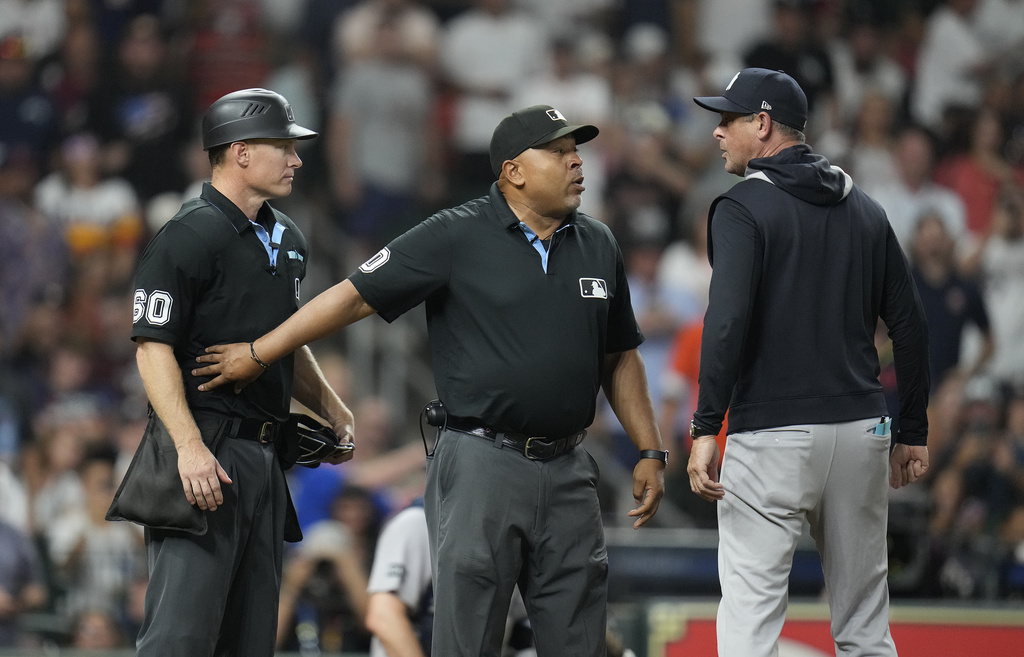 New York Yankees manager Aaron Boone, right, has words with home plate umpire Brian Walsh, left, as umpire Adrian Johnson, center, stands between them after Boone was ejected during the eighth inning of a baseball game Wednesday, Sept. 3, 2025, in Houston. (AP Photo/Karen Warren)