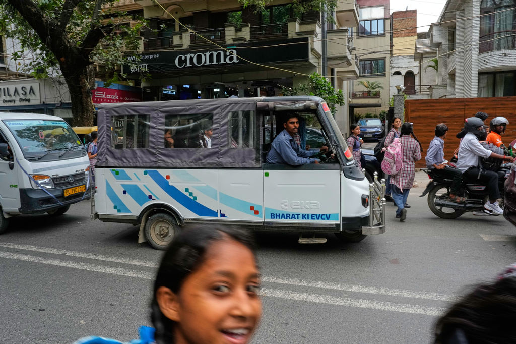 An electric vehicle maneuvers down a road in New Delhi, India, Monday, July 13, 2026. (AP Photo/Manish Swarup)