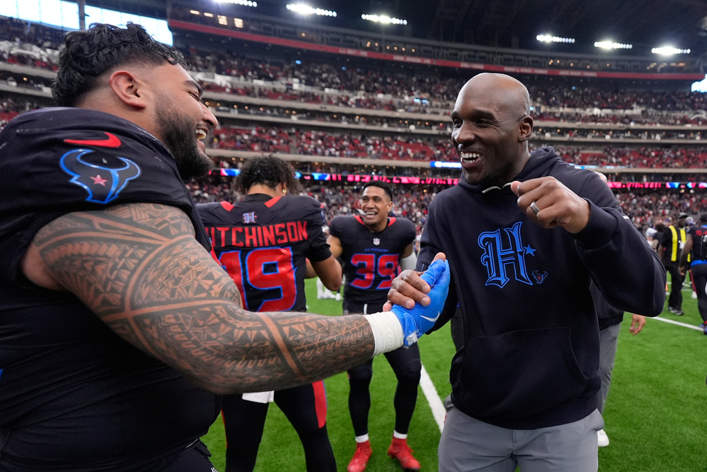 Houston Texans defensive tackle Tommy Togiai, left, celebrates his touchdown against the Indianapolis Colts with head coach Demeco Ryans, right, during the second half of an NFL football game in Houston, Sunday, Jan. 4, 2026. (AP Photo/Ashley Landis)