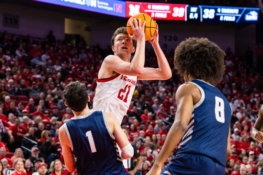 Nebraska forward Pryce Sandfort (21) looks to shoot against New Hampshire guards Jack Graham (1) and KiJan Robinson (8) during the first half of an NCAA college basketball game, Tuesday, Dec. 30, 2025, in Lincoln, Neb. (AP Photo/Bonnie Ryan)