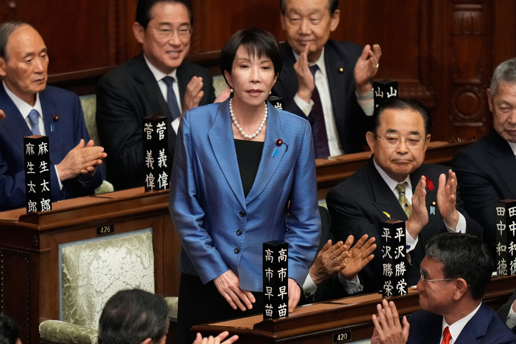 Lawmakers applaud as Sanae Takaichi, standing, was elected as Japan's new prime minister during the extraordinary session of the lower house, in Tokyo, Japan, Tuesday, Oct. 21, 2025.(AP Photo/Eugene Hoshiko)