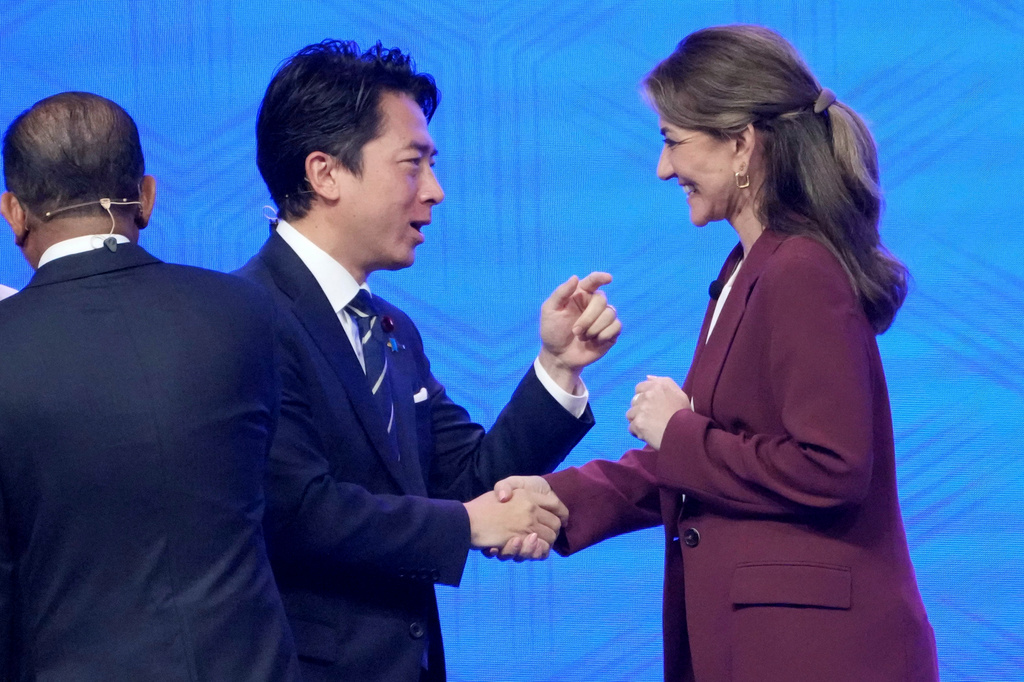 Japan's Defense Minister Shinjiro Koizumi, center, shakes hands with Netherland's Defense Minister Dilan Yesilgoz Zegerius, right, during the Shangri-La Dialogue, Asia's annual defense and security forum, in Singapore, Sunday, May 31, 2026. (AP Photo/Achmad Ibrahim)